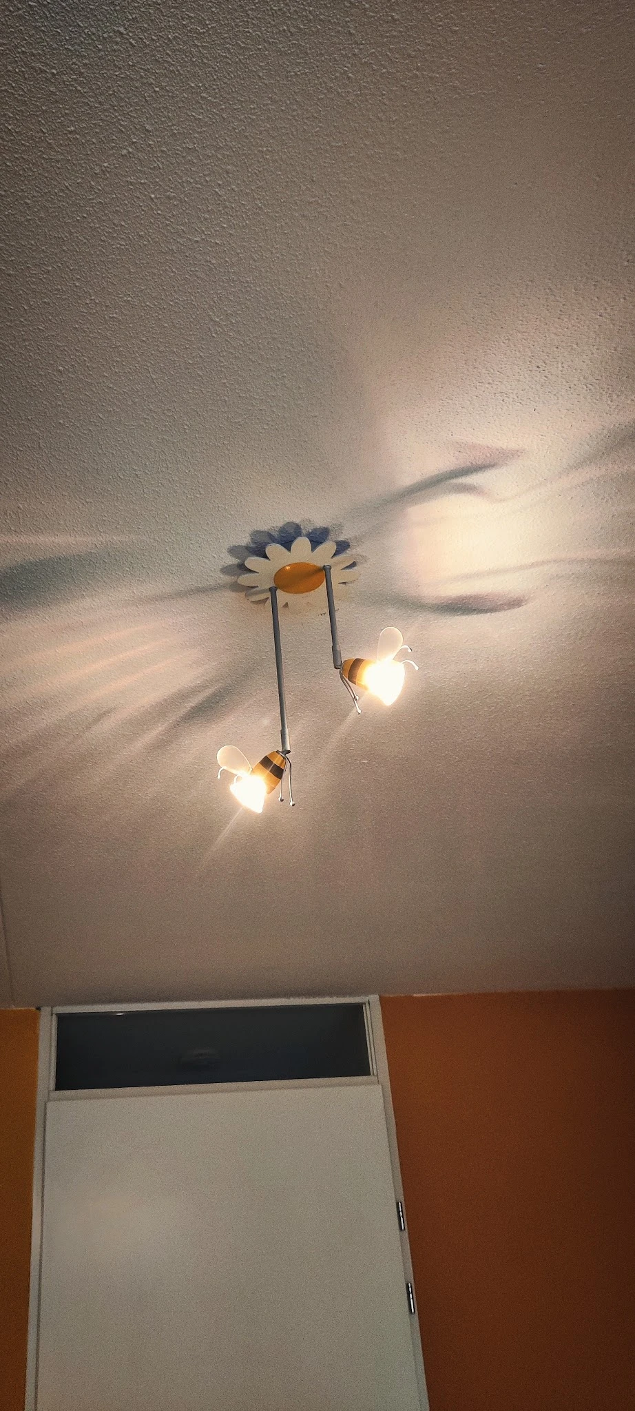 Plafondlamp in de vorm van een bloem met twee insecten (bijen) als hangende lichtarmaturen