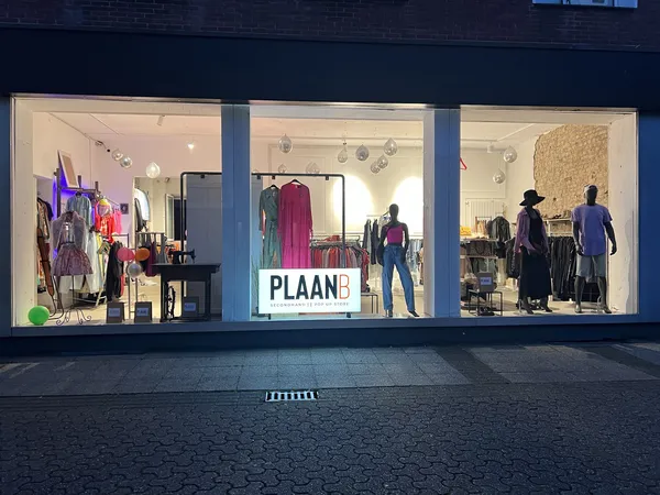 Winkelruit van kledingwinkel met etalages en mannequins in verschillende outfits