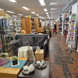 Winkelvloer van kringloopwinkel met rekken, toonbanken en uitgestalde huishoudartikelen en meubels
