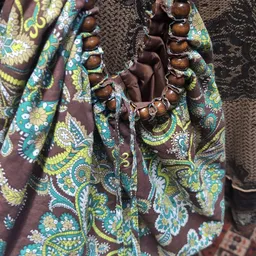 Uitgestalde tweedehands kleding met kleurrijke etnische prints en bruine tinten