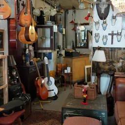 Winkelinterieur met muziekinstrumenten, religieuze artikelen en diverse spullen aan muren en vloer