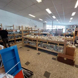 Winkelvloer met houten stellingen vol serviesgoed en huishoudelijke artikelen