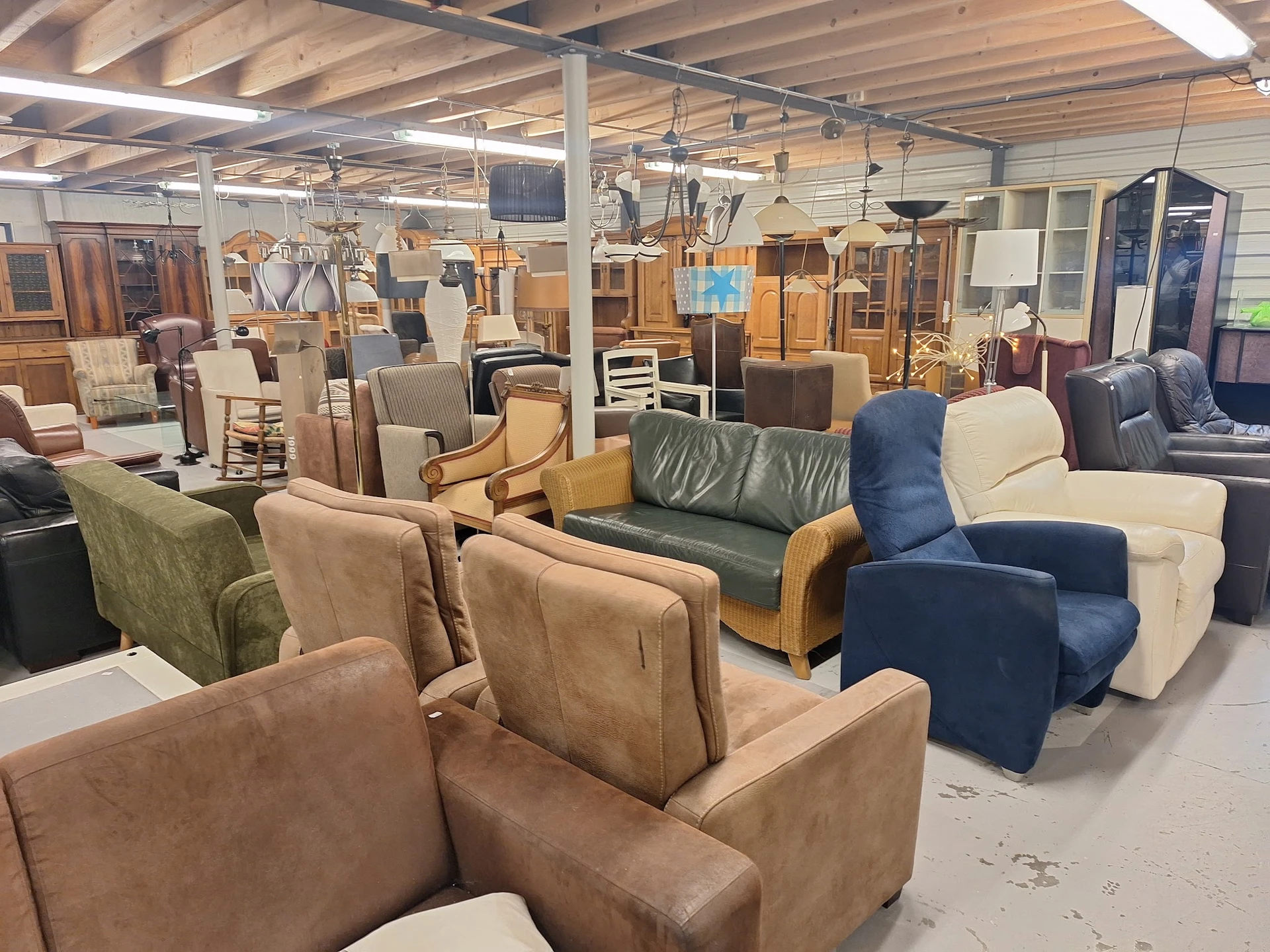 Diverse tweedehands stoelen en fauteuils uitgestald in de kringloopwinkel