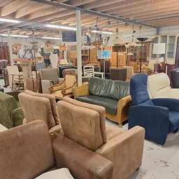 Diverse tweedehands stoelen en fauteuils uitgestald in de kringloopwinkel