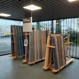 Houten stellingen met uitgestalde tapijten en vloerbekleding in verschillende kleuren en patronen