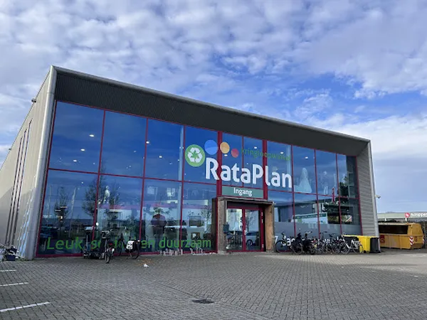 Gevel van kringloopwinkel met grote glazen pui en duidelijk zichtbare winkelnaambord.