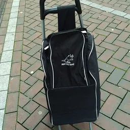 Zwarte trolleytas met wit logo 'Man the Road' op tegels buiten