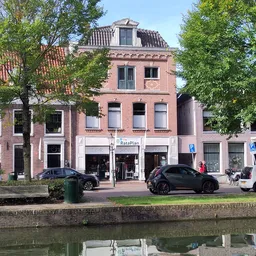 Voorgevel van RataPlan kringloopwinkel aan het water met winkelnaam op uithangbord zichtbaar