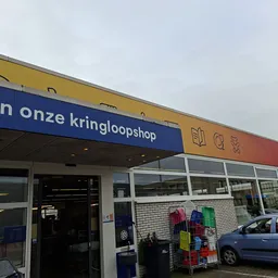 Gevel van RD4U kringloopshop met blauwe en gele luifel, winkelramen en ingang met uithangbord