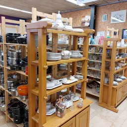 Houten stellingen met servies, borden en keukengerei in kringloopwinkel