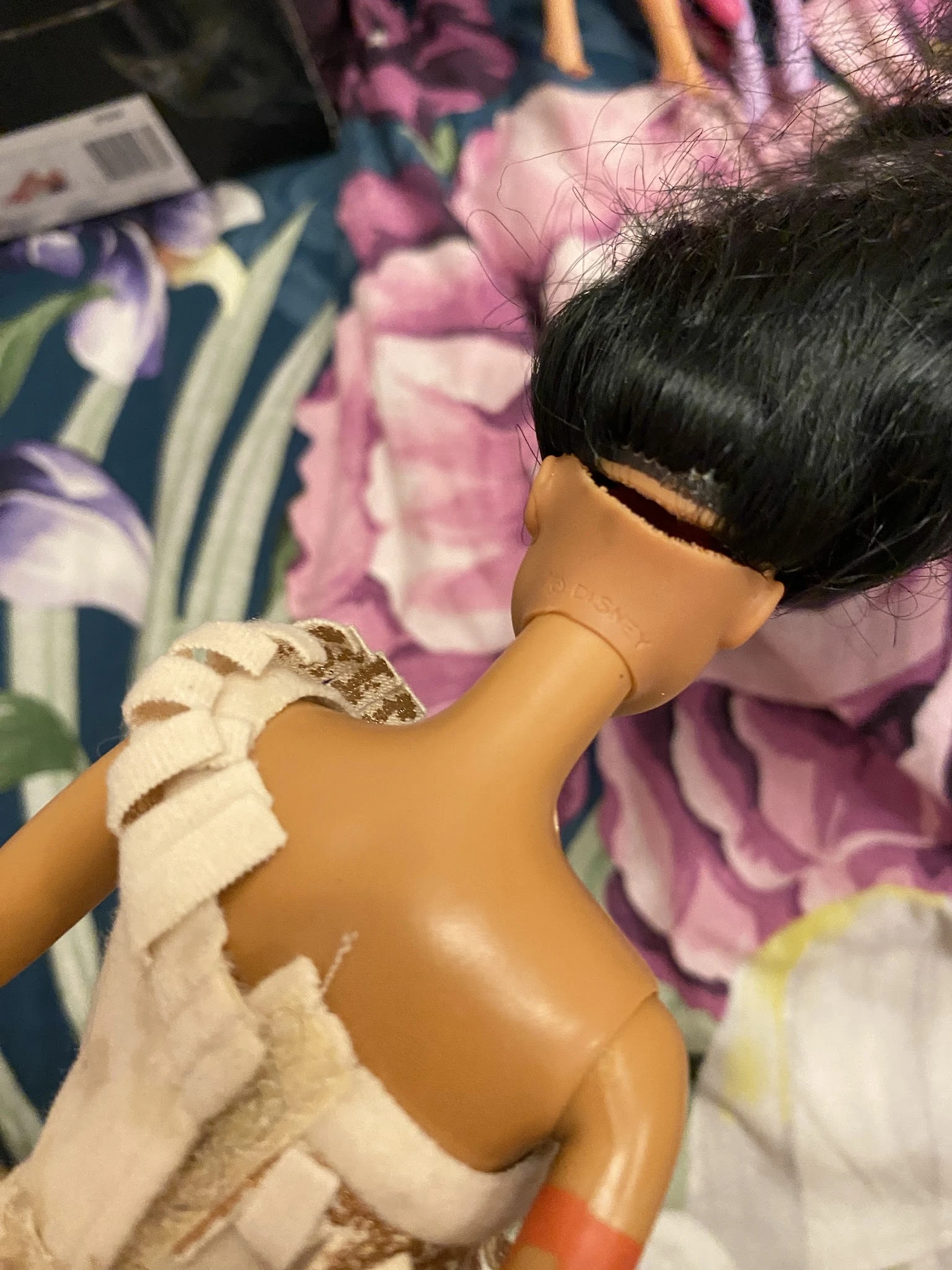 Close-up van een pop of mannequin met zwart haar en wit kledingstuk