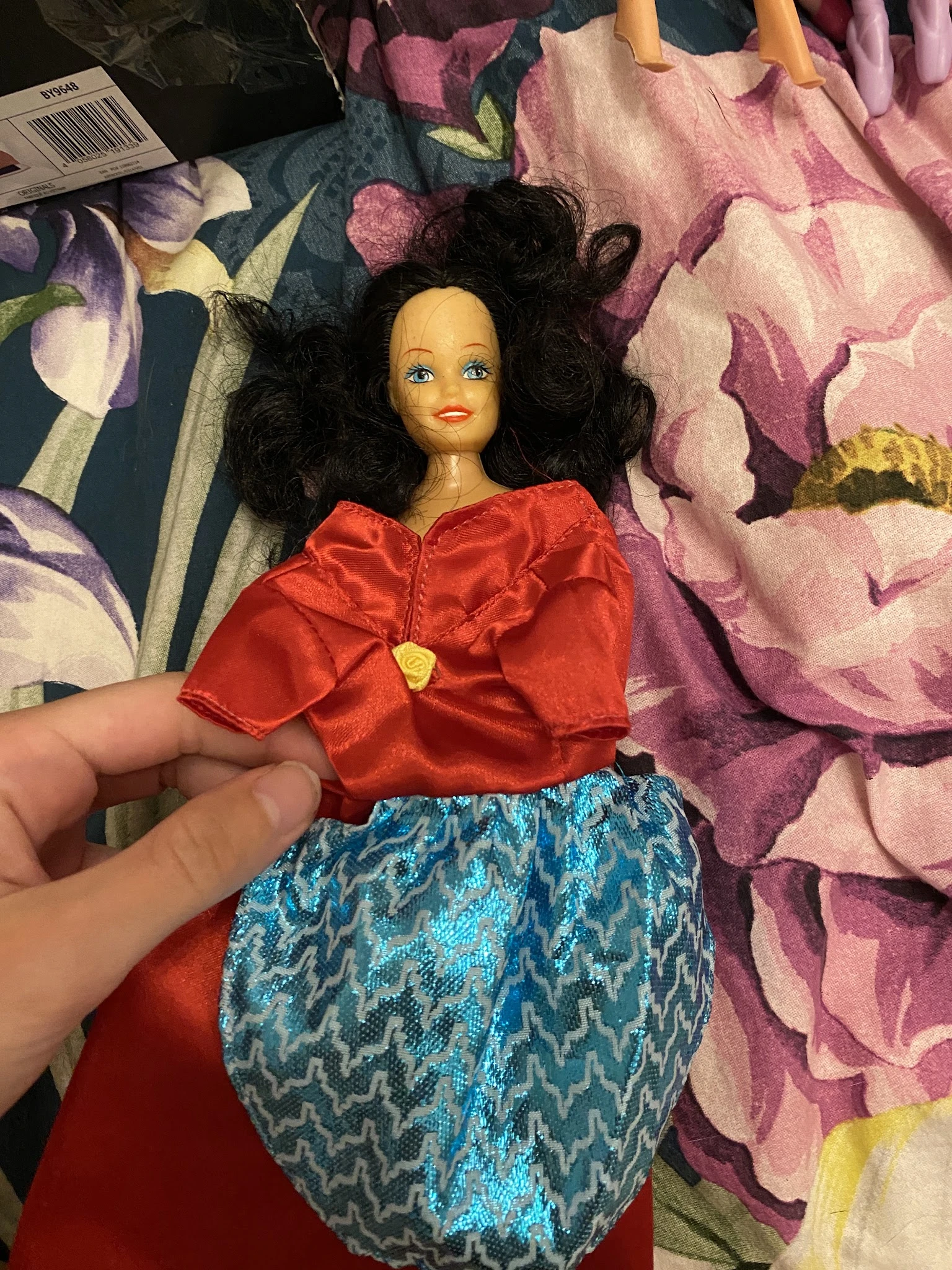 Close-up van vintage Barbie-pop met zwart haar, rode blouse en blauwe rok