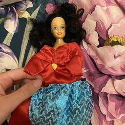 Close-up van vintage Barbie-pop met zwart haar, rode blouse en blauwe rok