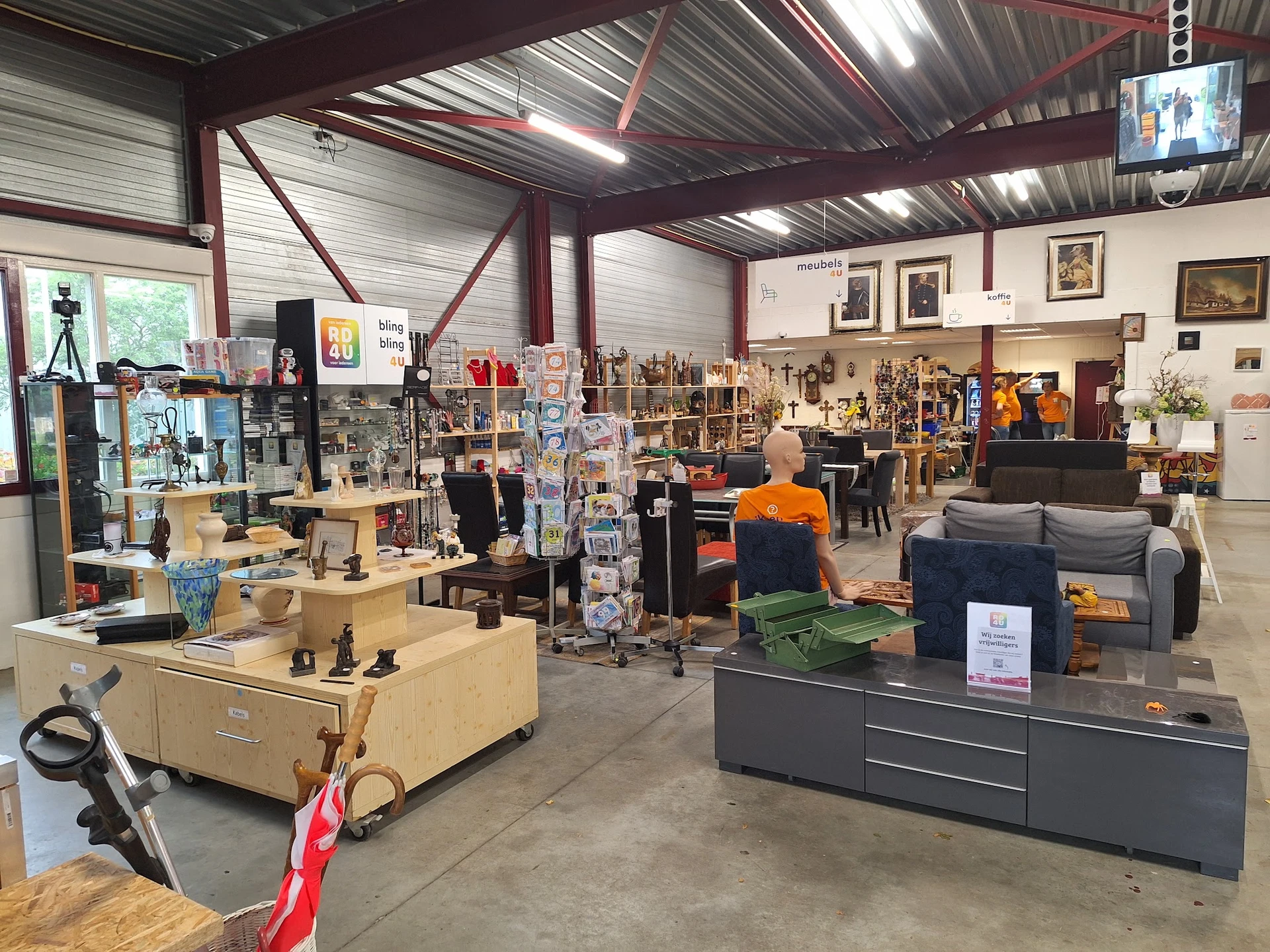 Ruim magazijn met stellingen, meubels en diverse tweedehands spullen uitgestald