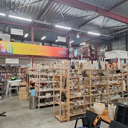 Winkelvloer met houten stellingen vol diverse tweedehands spullen en huishoudartikelen