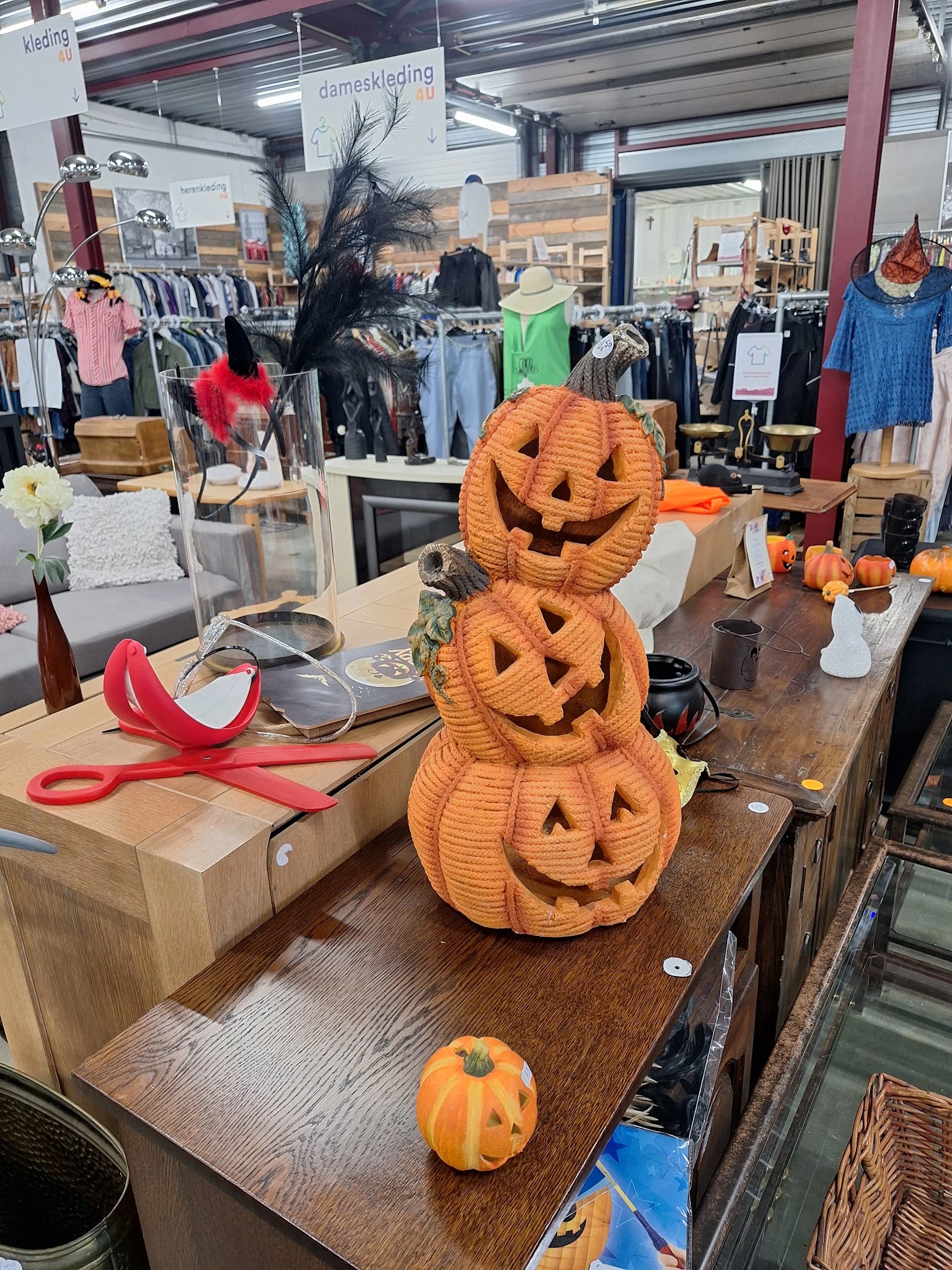 Decoratieve Halloween-pompoenen gestapeld op een toonbank in de winkel, omringd door ander seizoensgebonden decor