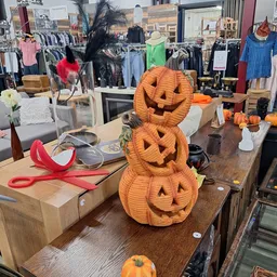 Decoratieve Halloween-pompoenen gestapeld op een toonbank in de winkel, omringd door ander seizoensgebonden decor