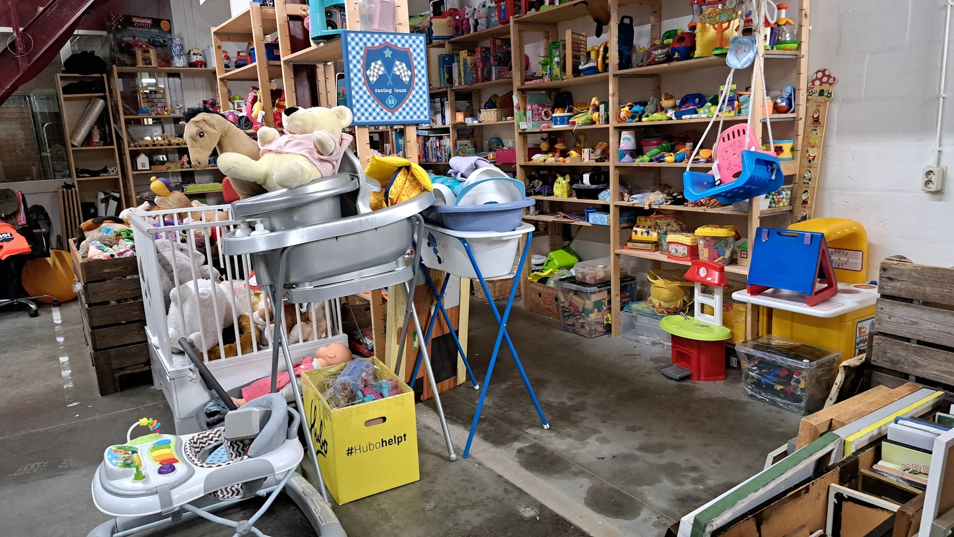Winkelvloer met speelgoedrekken, opslag en diverse tweedehands artikelen in een kringloopwinkel