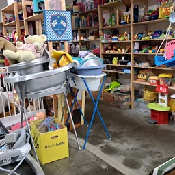 Winkelvloer met speelgoedrekken, opslag en diverse tweedehands artikelen in een kringloopwinkel