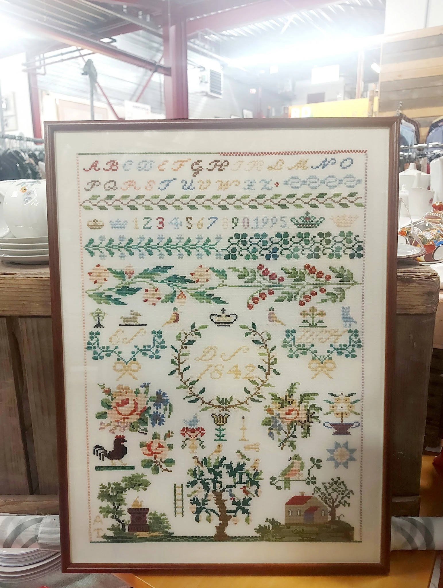 Ingelijste cross-stitch of borduurwerk met alfabetten, nummers, bloemmotieven en decoratieve patronen