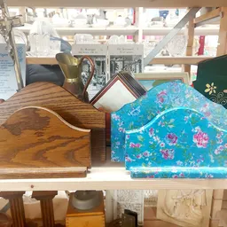 Twee huisvorming houtenboxen op een plank, links naturel hout, rechts turquoise met bloemenpatroon