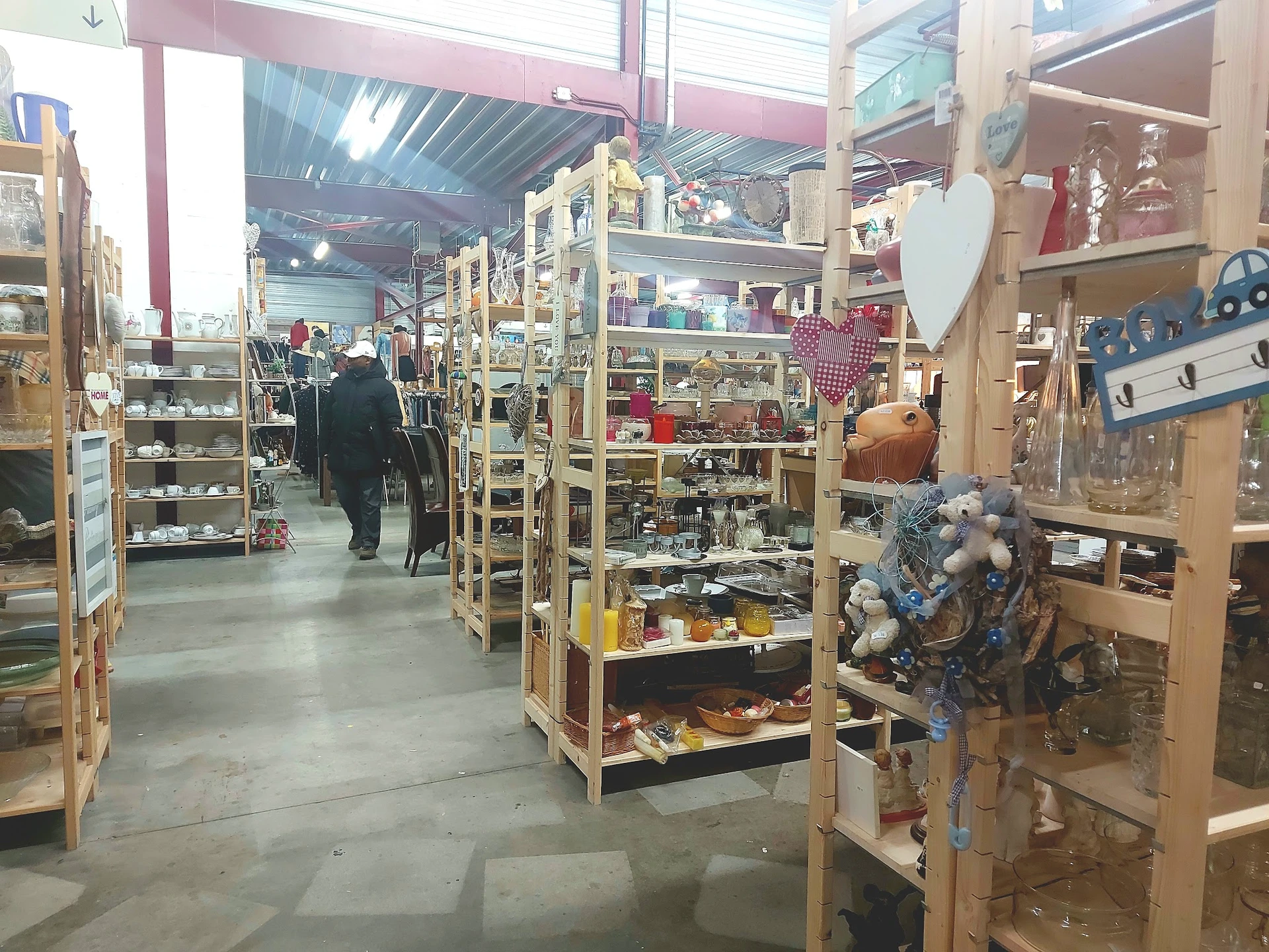 Winkelvloer met houten stellingen vol tweedehands spullen, decoratie en huisraad in een kringloopwinkel