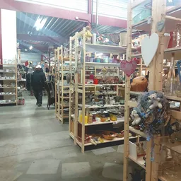 Winkelvloer met houten stellingen vol tweedehands spullen, decoratie en huisraad in een kringloopwinkel