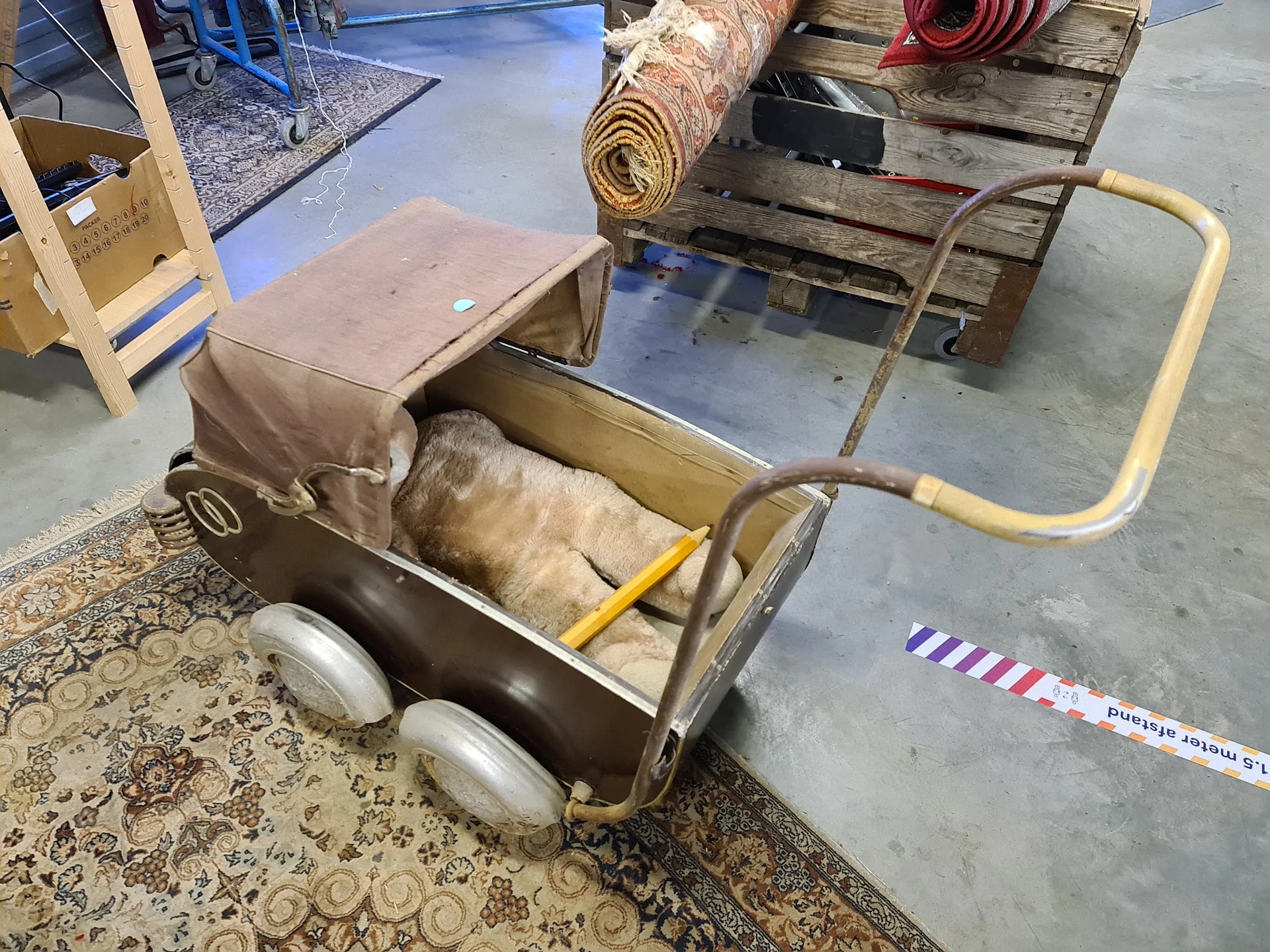 Vintage kinderwagen met bruine stof en gele metalen frame op wielen