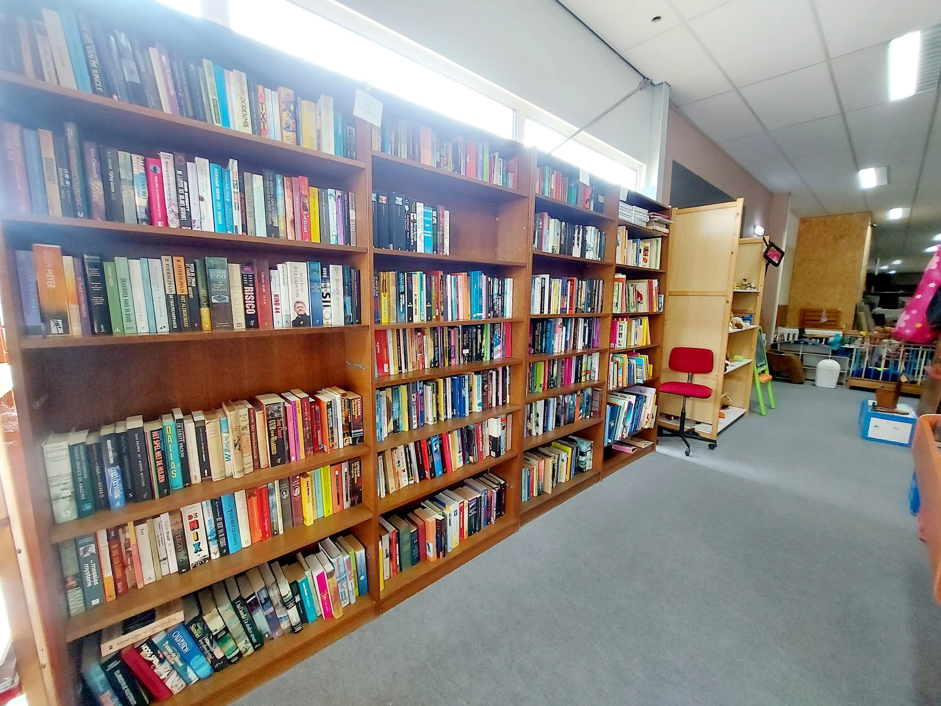Houten boekenkasten vol met tweedehands boeken in een kringloopwinkel