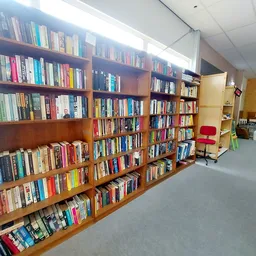 Houten boekenkasten vol met tweedehands boeken in een kringloopwinkel
