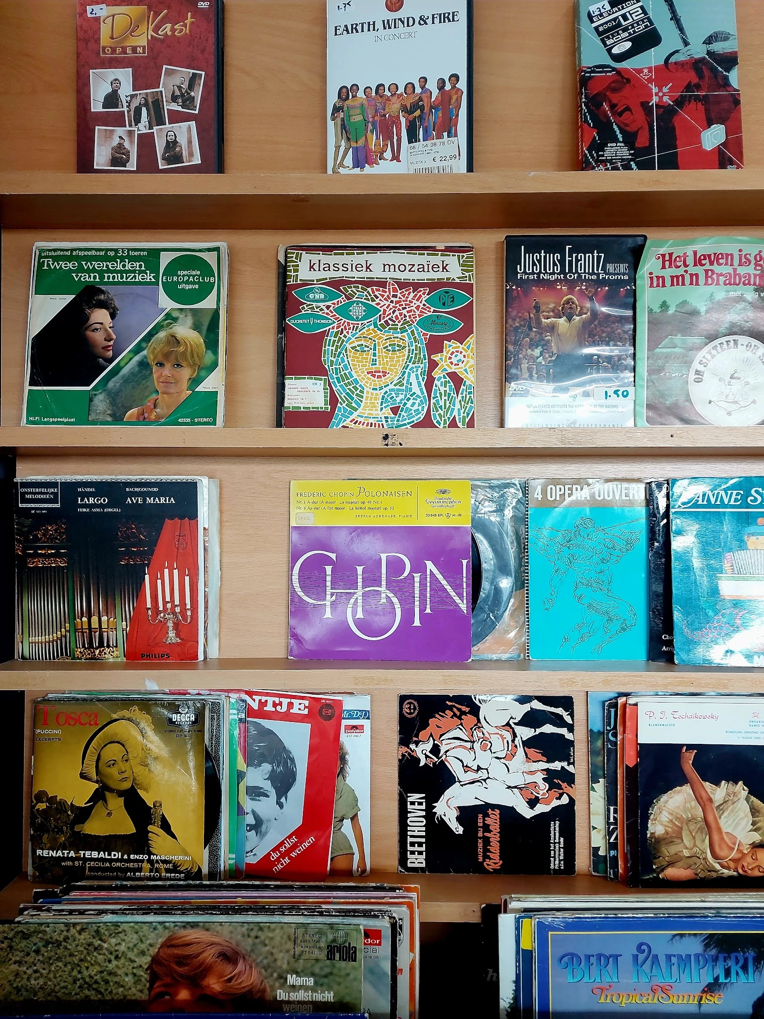 Planken met tweedehands vinyl records en muziekalbums van verschillende genres