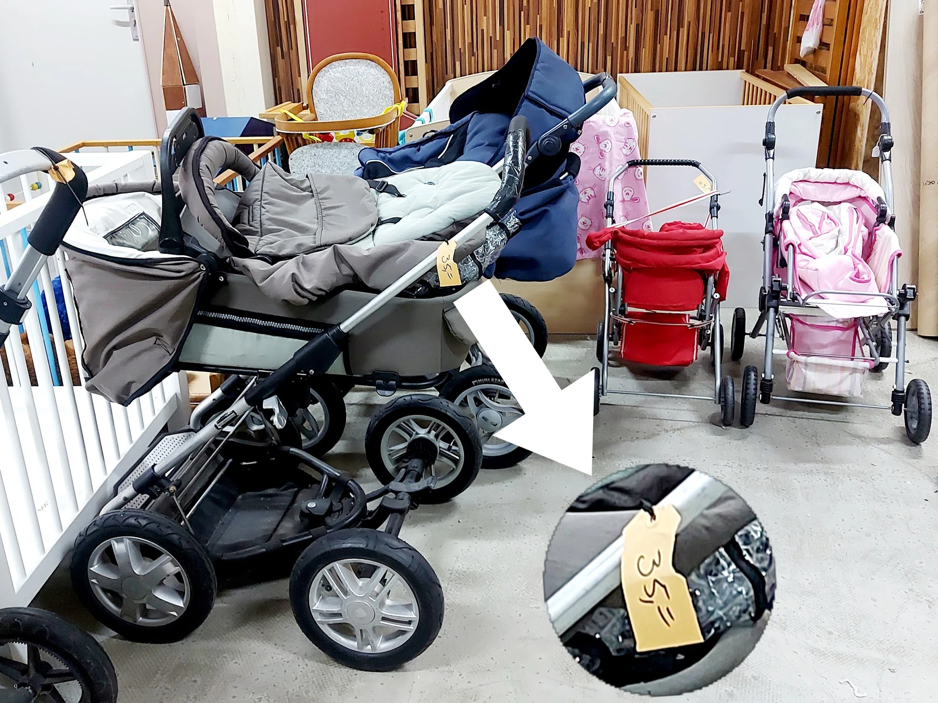 Diverse tweedehands kinderwagens en buggy's uitgestald in de winkel, waaronder modellen in zwart, blauw, roze en rood