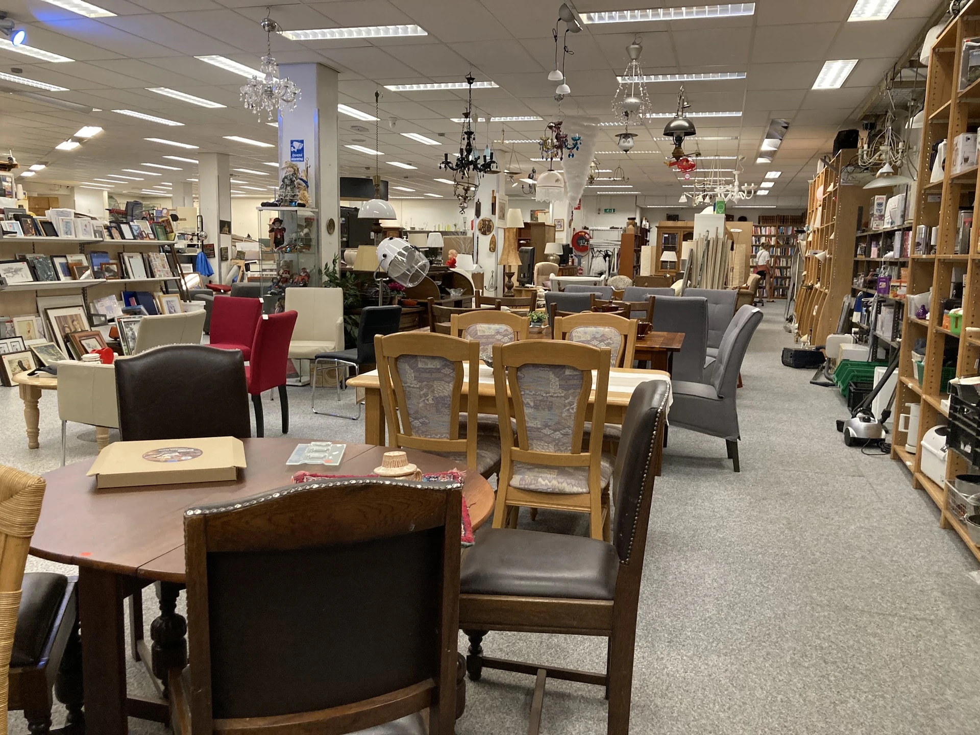 Winkelvloer met meubels, stoelen, tafels en boekenkasten in een kringloopwinkel