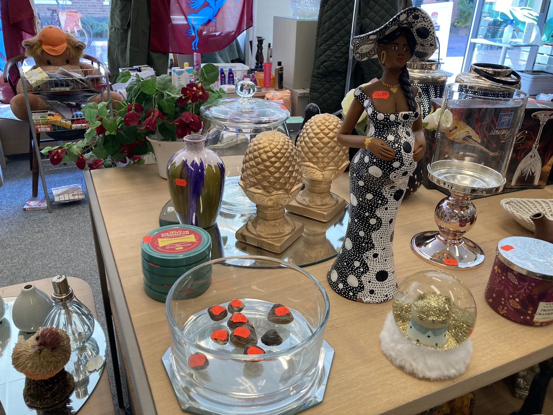 Uitstallingtafel met decoratieve objecten, bloemen, kasten en huishoudspullen