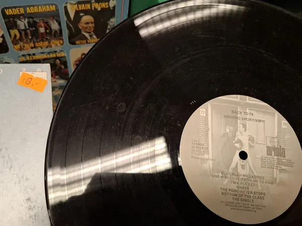 Zwarte vinyl LP met witte labelzijde, zichtbaar in kringloopwinkel