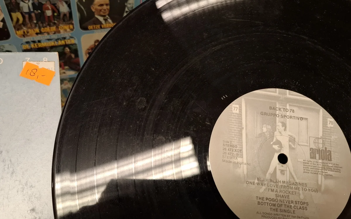 Vinyl LP-plaat met witte label en zwarte plaat, geplaatst tegen grijze achtergrond