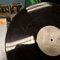 Vinyl LP-plaat met witte label en zwarte plaat, geplaatst tegen grijze achtergrond