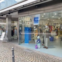 Winkelfront van ReSales aan Grosskölnstraße met grote glazen pui, etalage met kledingmanequins en blauwe 'ReSales' bord