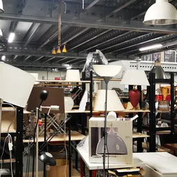 Winkelvloer met uitgestalde meubels, lampen en huisraad in een kringloopwinkel