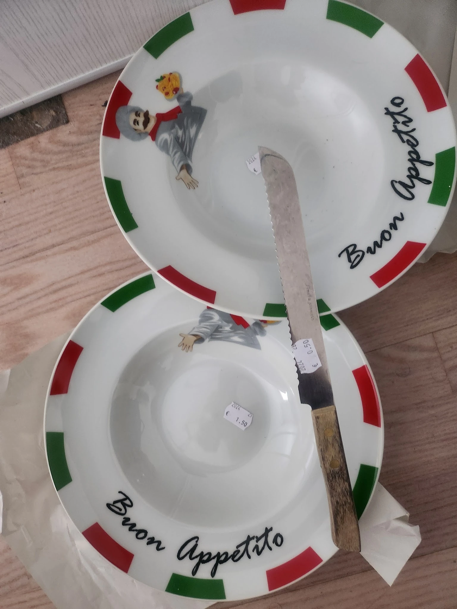 Twee witte borden met Italiaanse vlag en text, met een mes ernaast