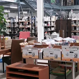 Winkelinterieur met houten meubels, displaytafels en stellingen met diverse goederen