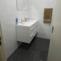 Badkamer met witte wastafelmeubilair, spiegel en tegels