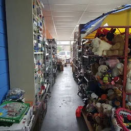 Winkelgang met stellingen vol speelgoed en knuffels in een kringloopwinkel