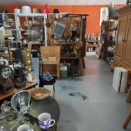 Winkelvloer van kringloopwinkel met diverse meubels, lampen, huishoudelijke spullen en decoratie uitgestald