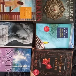 Boekenrek met verschillende tweedehands boeken, waaronder romans en literaire werken op elkaar gestapeld