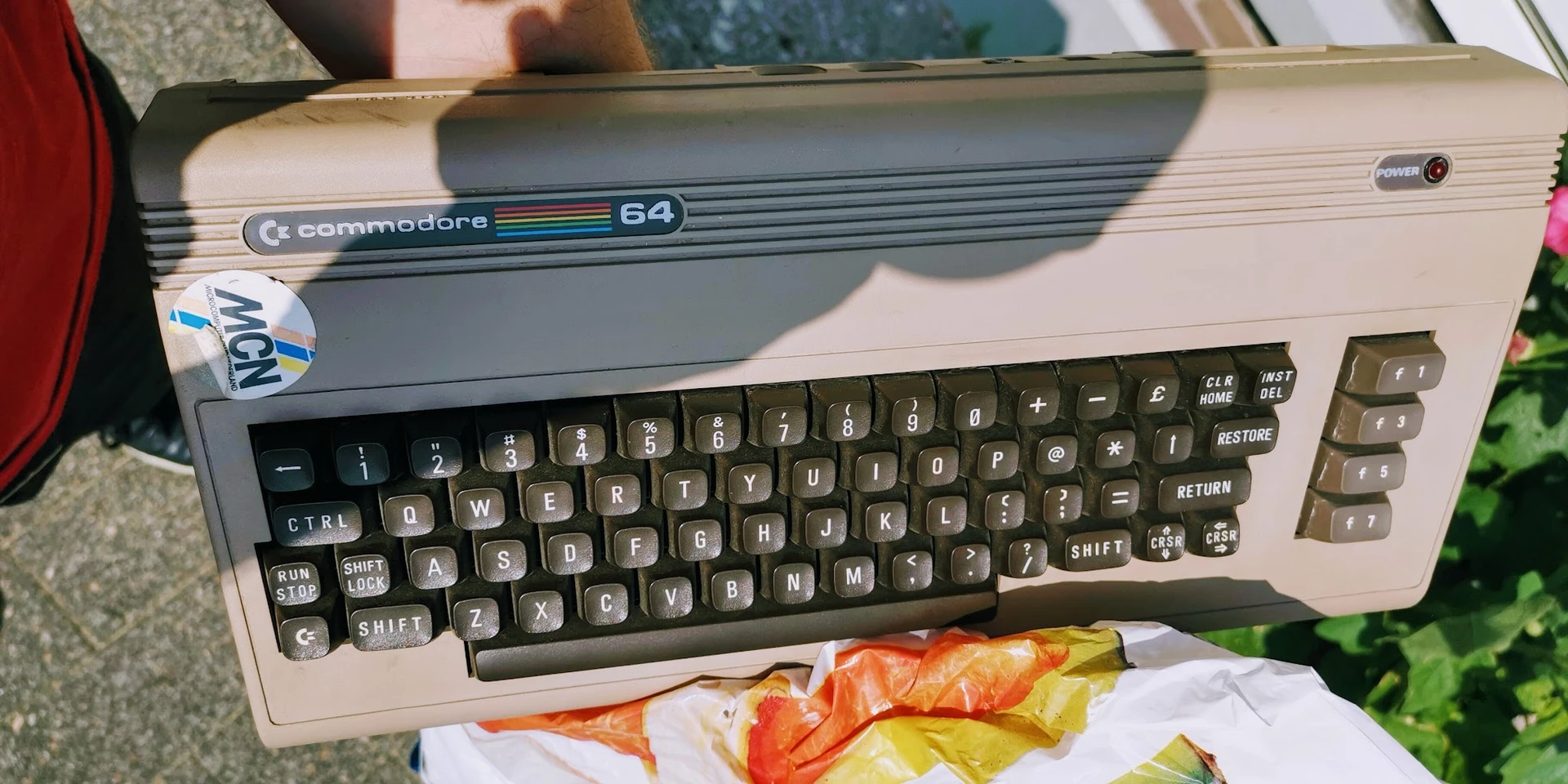 Commodore 64 computer met toetsenbord en kleurrijke sjaals eronder