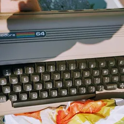 Commodore 64 computer met toetsenbord en kleurrijke sjaals eronder