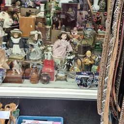 Vitrinekast met verzameling poppen, beeldjes, servies en decoratieve voorwerpen