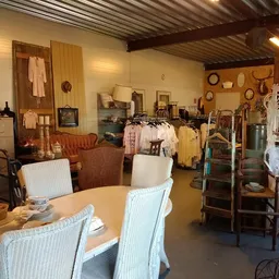 Winkelvloer met tafels, stoelen, kledingrekken en diverse tweedehands artikelen