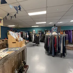 Winkelvloer met kledingrekken, mannequins en uitgestalde vintage kleding in verschillende kleuren